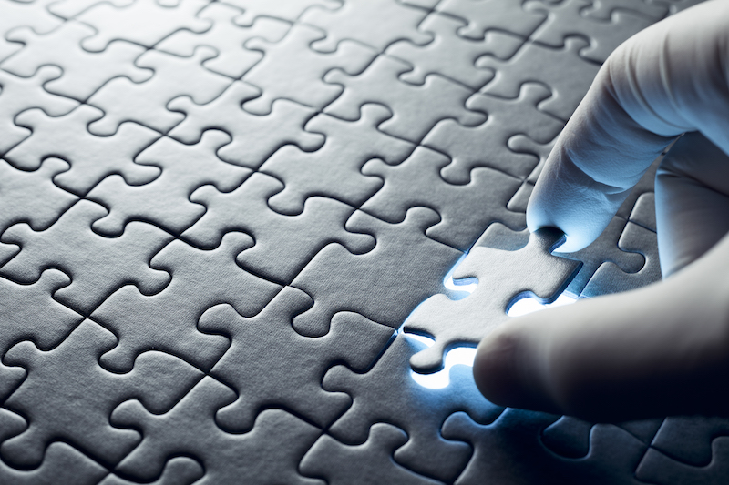 Hand inserting missing puzzle piece